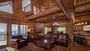 A log cabin interior with a living area featuring leather sofas, a coffee table, and a chandelier. - Fabulous Log Home - 2 Master Bedrooms! (Tabernash)