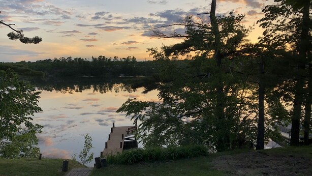A lakeside view with a dock and a bench.