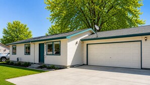 Ein eingeschossiges Haus mit Garage, Eingangstür und kleiner Veranda.