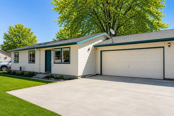 A single-story house with a garage, a front door, and a small porch.