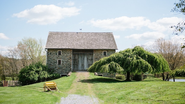 A stone building with a sloped roof, a wooden door, and a small window.