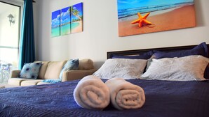 Une chambre d’hôtel avec un lit, un canapé et des œuvres d’art accrochées aux murs.