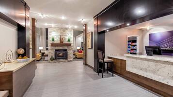 Un intérieur moderne avec une cheminée, un coin salon et un comptoir d’accueil.