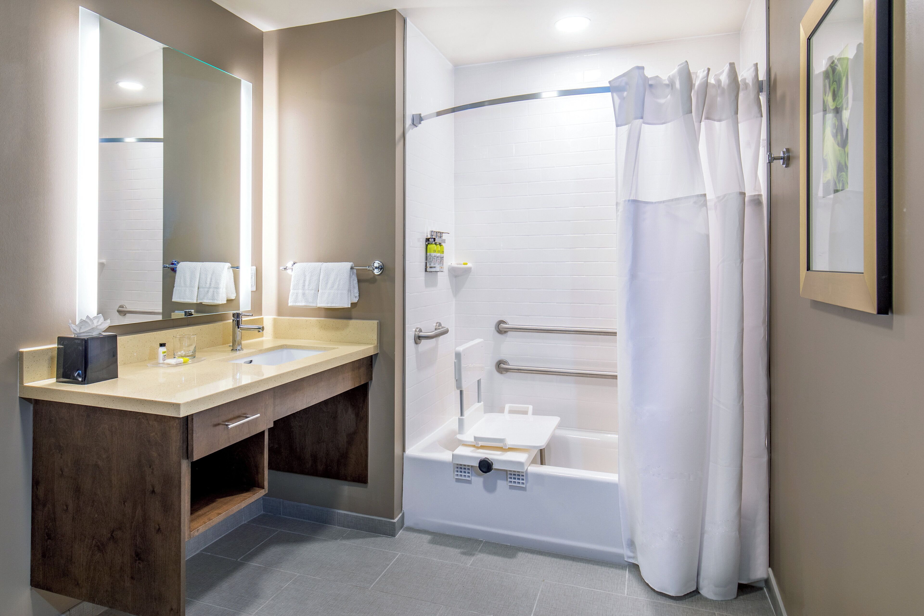 A modern bathroom with a vanity, a bathtub, and a shower curtain.