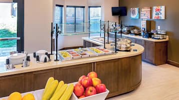 Un espace buffet proposant divers plats et une présentation attrayante de fruits.
