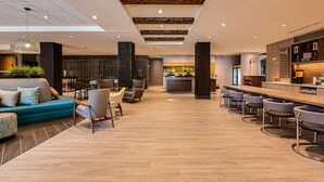 A modern hotel lobby with a bar area, seating arrangements, and a reception desk. - Home2 Suites by Hilton Nashville Bellevue (Nashville)