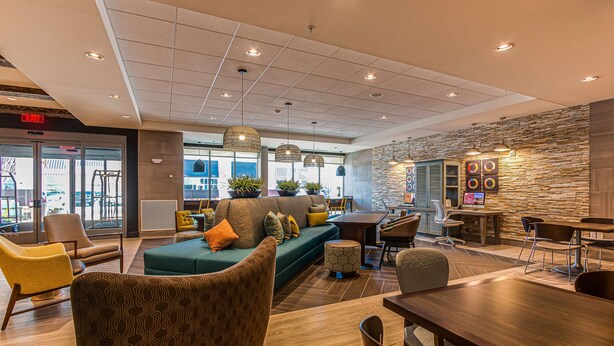 A modern hotel lobby with a seating area, a reception desk, and a stone accent wall. - Home2 Suites by Hilton Nashville Bellevue (Nashville)