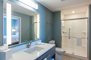 Ein modernes Badezimmer mit großem Spiegel, einem Doppelwaschbecken, Toilette und einer Duschkabine.