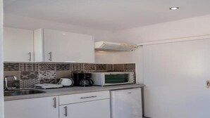 A compact kitchen with white cabinets, a microwave, a coffee maker, and a small refrigerator. - Kefalonian 360° Sunrise (Kefalonia)