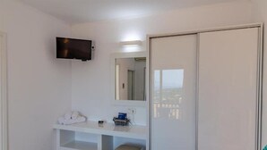 A modern bathroom with a white vanity, a mounted TV, and a large mirror. - Kefalonian 360° Sunrise (Kefalonia)