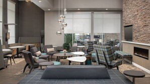 A modern lounge area with seating, tables, and a fireplace. - Residence Inn by Marriott Modesto North (Modesto)