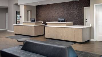 A reception area with two counters, a seating area with a sofa, and a patterned wall.