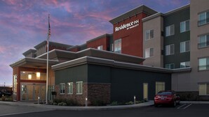 A multi-story hotel with a modern facade, featuring a prominent entrance with glass doors and a flagpole. - Residence Inn by Marriott Modesto North (Modesto)