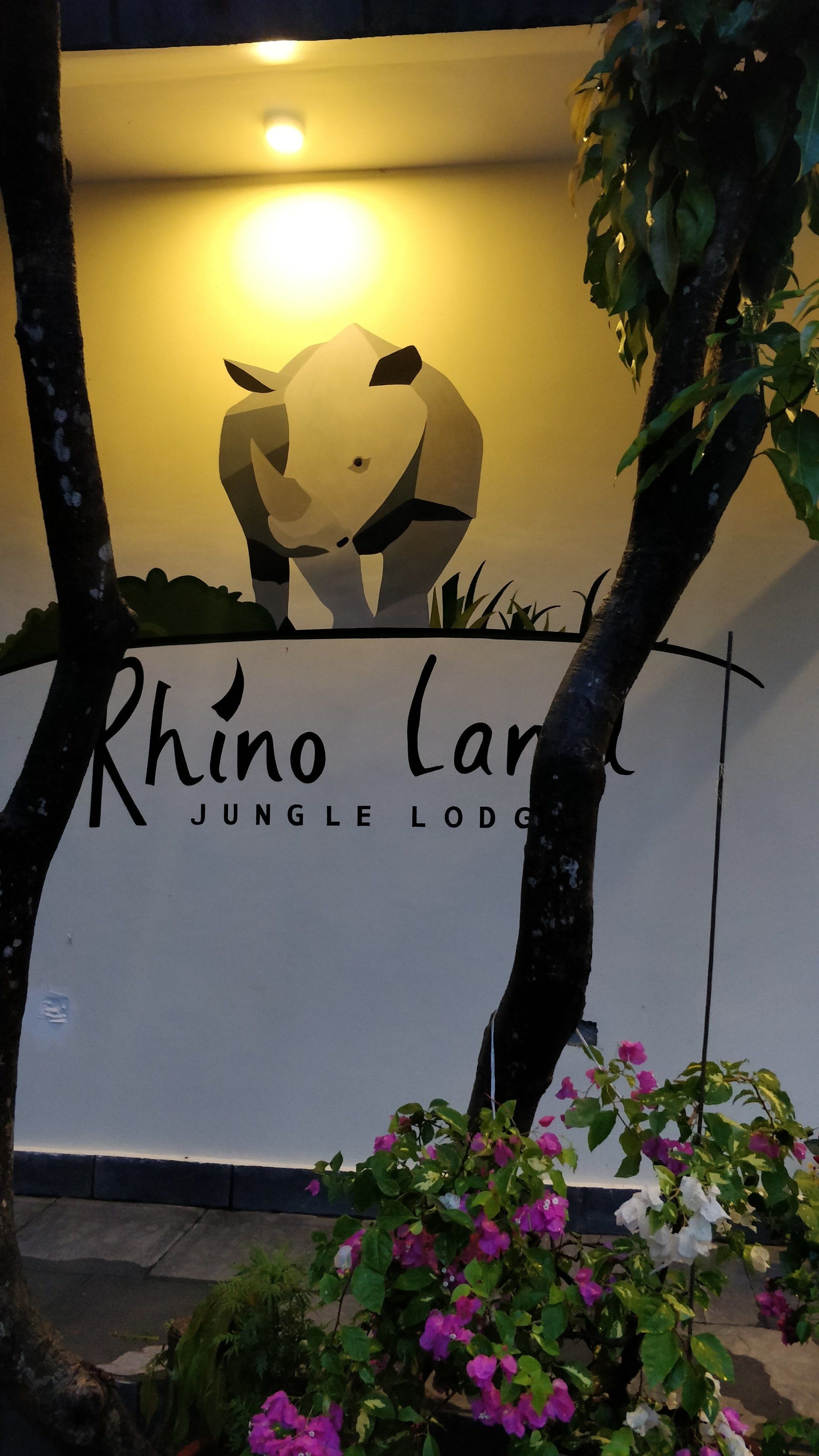 A sign for Rhino Land Jungle Lodge with a stylized elephant and text.