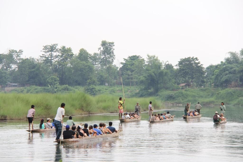 Several boats on a river with passengers.