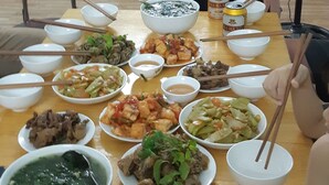A dining table with various dishes and a person standing behind it.