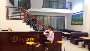 A reception area with a staircase, a reception desk, and seating arrangements.