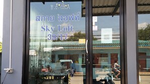 Entrada de hotel con puerta de vidrio que muestra el nombre "Sky Loft" y la dirección "39/17".