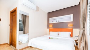 A hotel room with a bed, a mirror, a nightstand, and a wall-mounted light fixture. - 7 Days Premium Hotel (Phnom Penh)