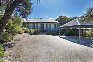 A two-story building with a covered porch and a gravel driveway. - Poolside Sorrento Pet Friendly (SORRENTO)