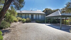 A two-story house with a covered porch and a gravel driveway. - Poolside Sorrento (SORRENTO)