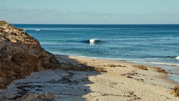 A beach with a rocky cliff and a sandy shore. - Back Beach Hideaway - Family friendly beach house (BLAIRGOWRIE)
