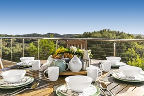 A table set for breakfast with white dishes, a pitcher, and a vase of flowers. - Dunescape Spacious Rye Retreat with Private Pool (RYE)