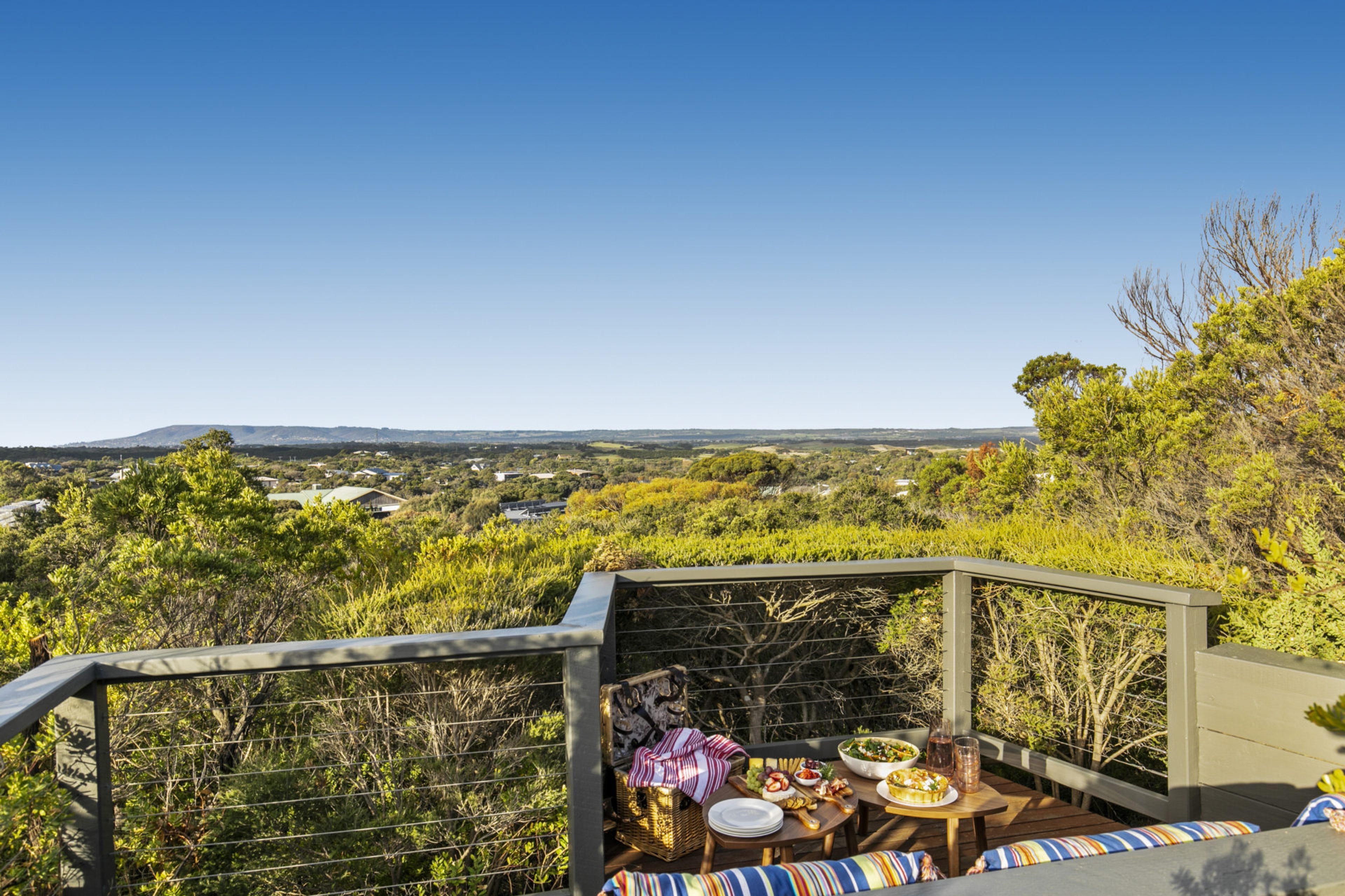 A dining area with a table set for a meal, overlooking a scenic landscape.