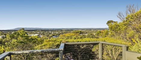 A dining area with a table set for a meal, overlooking a scenic landscape.