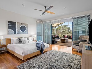 A bedroom with a large bed, a ceiling fan, a view of the outdoors, and a balcony with furniture. - Diamond View Sorrento Holiday Home with Pool (Sorrento)