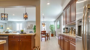 A modern kitchen with wooden cabinets, stainless steel appliances, and a central island. - 1000 MBPS Fast Wifi★Model Home★Luxury Family Retreat 5B/4b (Jurupa Valley)