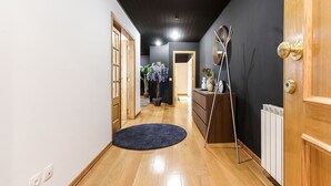 A hallway with wooden flooring, a dark wall, and a door with a golden knob. - Luxurious & Modern central apt w / 4 rooms, private terrace and 2 parking spaces (Lisboa)