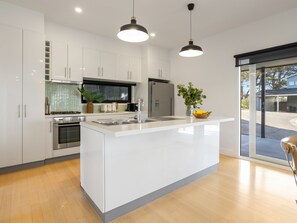 A modern kitchen with white cabinetry, stainless steel appliances, and a central island.