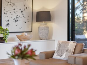 A living room with a sofa, a lamp, a bowl with eggs, and a framed picture on the wall.
