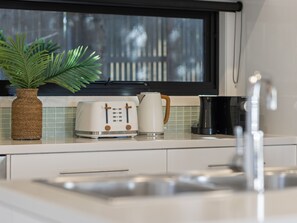 A kitchen with a toaster, a coffee maker, and a potted plant on the counter. - Corfu Sorrento with magnesium pool (SORRENTO)