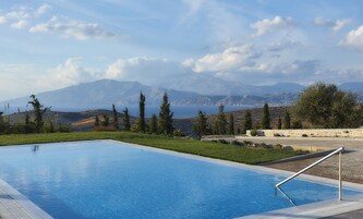 Una piscina con vistas despejadas a montañas y una masa de agua al fondo.