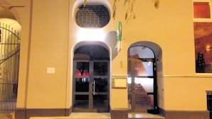 Una entrada de edificio con un gran arco y una ventana arqueada más pequeña a la derecha.