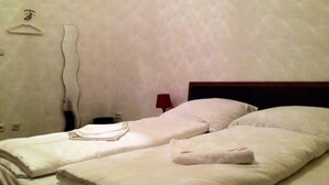 Una habitación con cama, perchero en la pared y una lámpara.