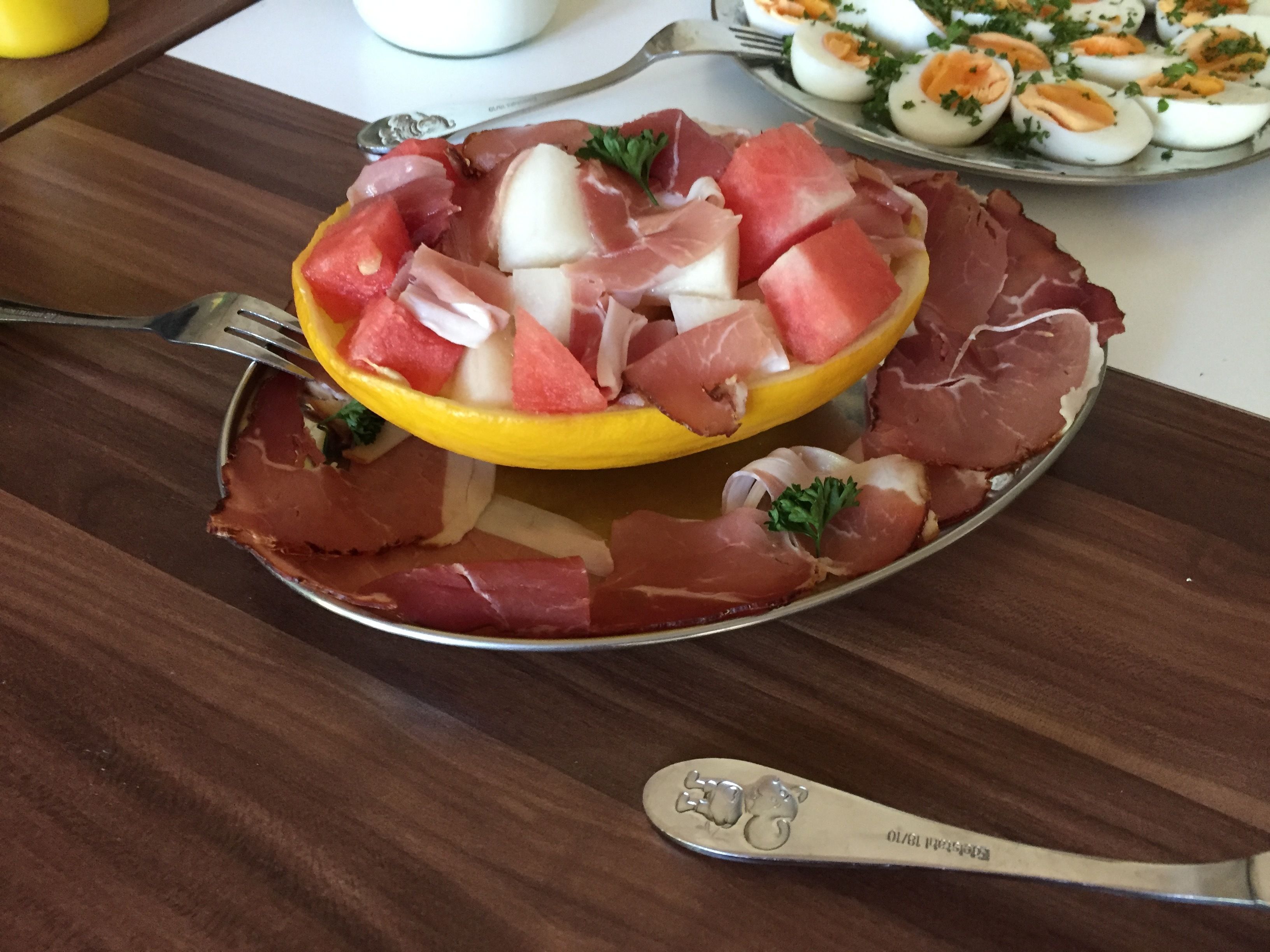 Un plato con jamón serrano, melón y queso.