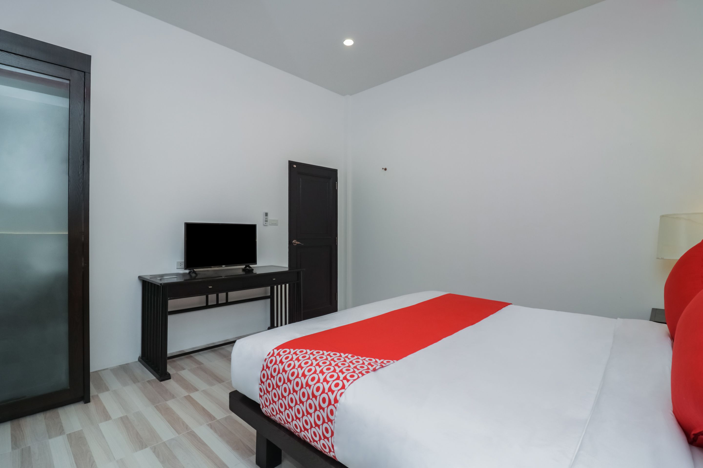 Une chambre d’hôtel comprenant un lit, un bureau, une télévision et une armoire.