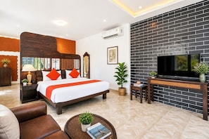A modern hotel room with a large bed, a television, a fireplace, and a potted plant. - Baan Noppadol Hua Hin Loft Hotel (Hua Hin)