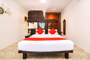 Een moderne hotelkamer met een groot bed, een accentmuur van baksteen en een fietsdecoratie aan de muur.