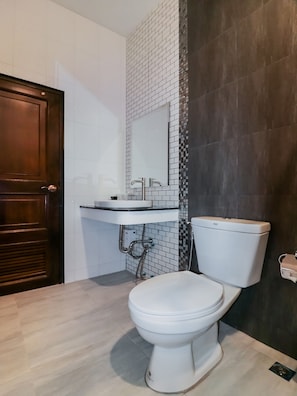 A modern bathroom with a white toilet, a sink, and a shower. - Baan Noppadol Hua Hin Loft Hotel (Hua Hin)