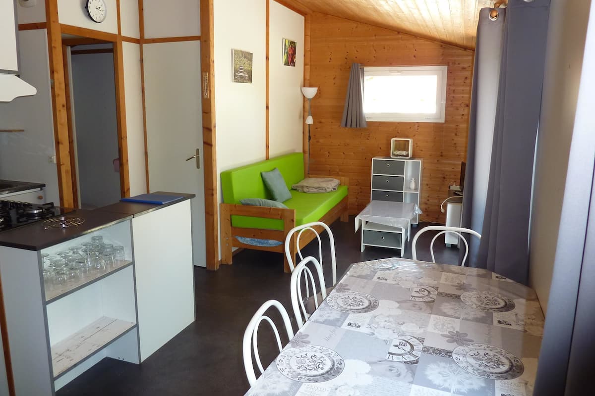 Cocina compacta con estufa y comedor con una mesa dispuesta para dos.