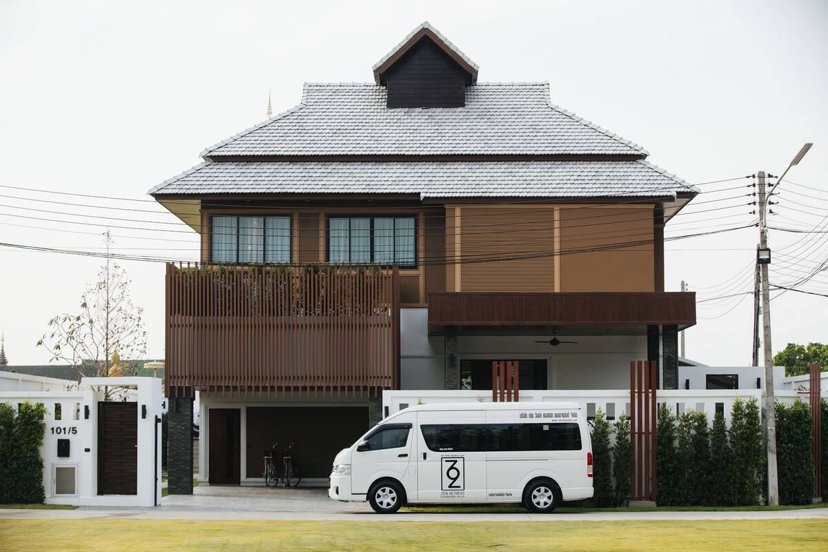 A modern two-story house with a garage and a white van parked in front.