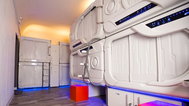 A modern spa room with multiple massage beds, a wooden floor, and a small seating area. - The Capsule Hotel (Colombo)