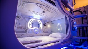 A medical imaging room with a bed, control panels, and a circular viewing window. - The Capsule Hotel (Colombo)
