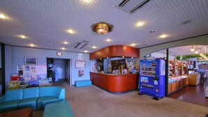 A lobby with a reception desk, seating area, vending machine, and a clock on the wall. - Lake Side Hotel MINATOYA (Inawashiro)