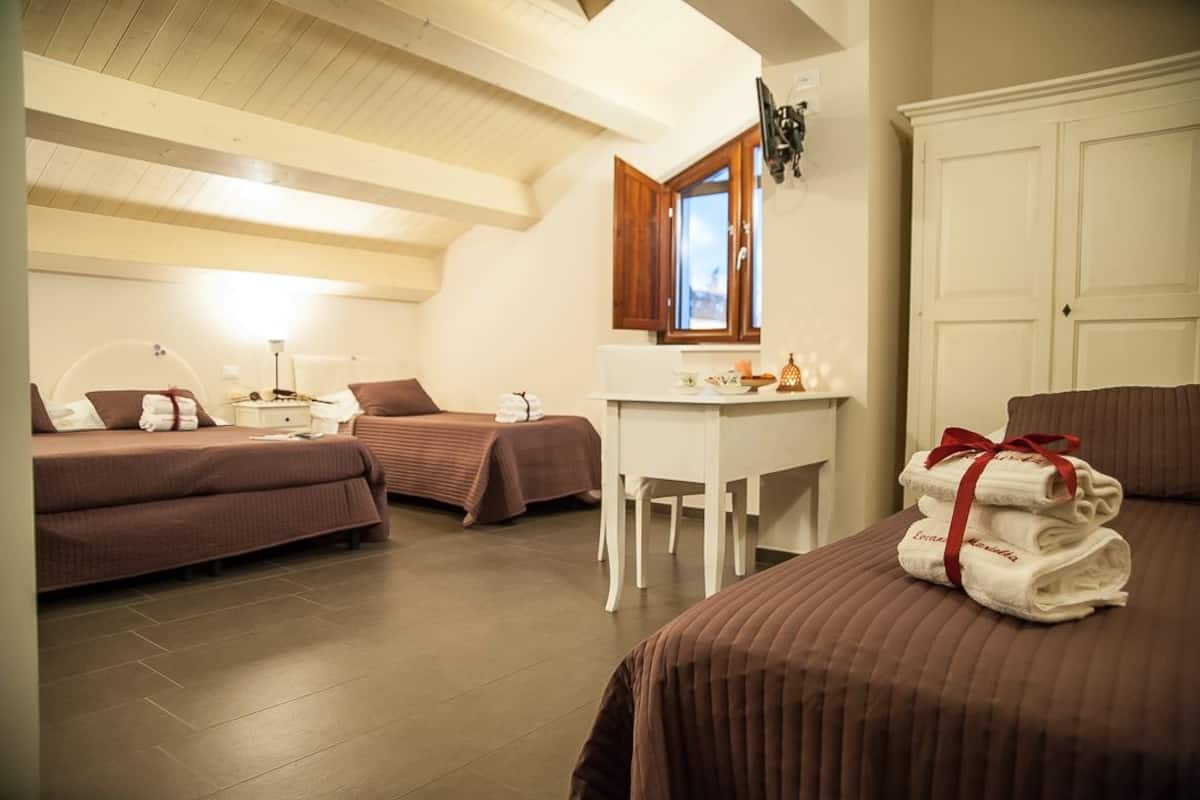 Une chambre d’hôtel avec deux lits, un bureau et une armoire.