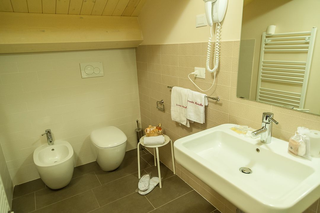 Une salle de bain équipée d’un bidet, de toilettes, d’un lavabo et d’un porte-serviettes.